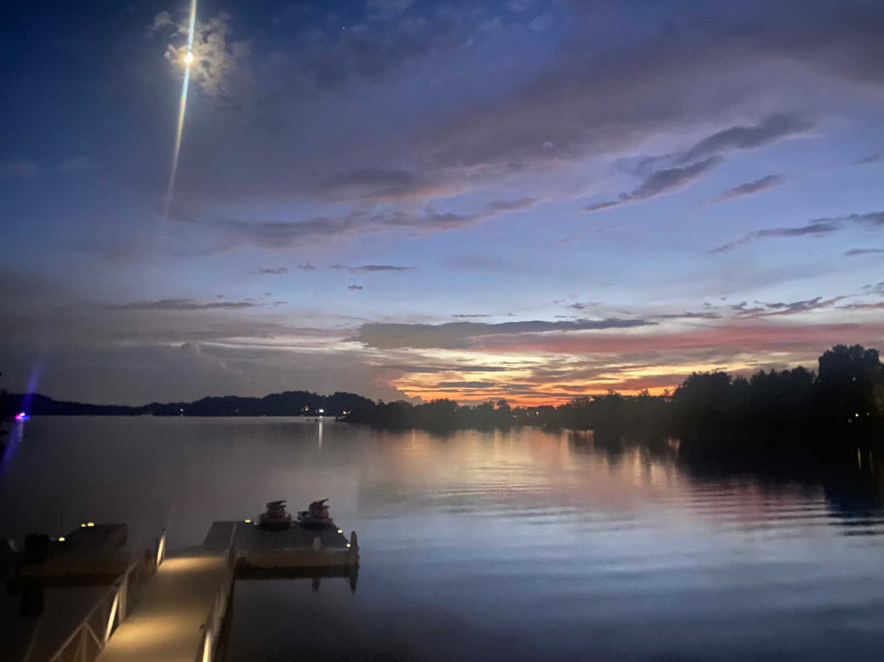 Twilight sunset reflecting on Douglas Lake with illuminated floating dock